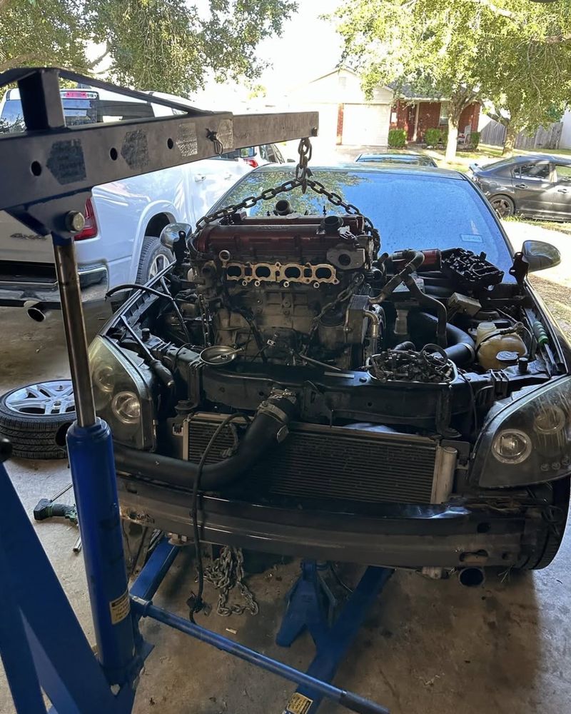An engine hoist lifting the LNF out of the Cobalt, chained at the cylinder head