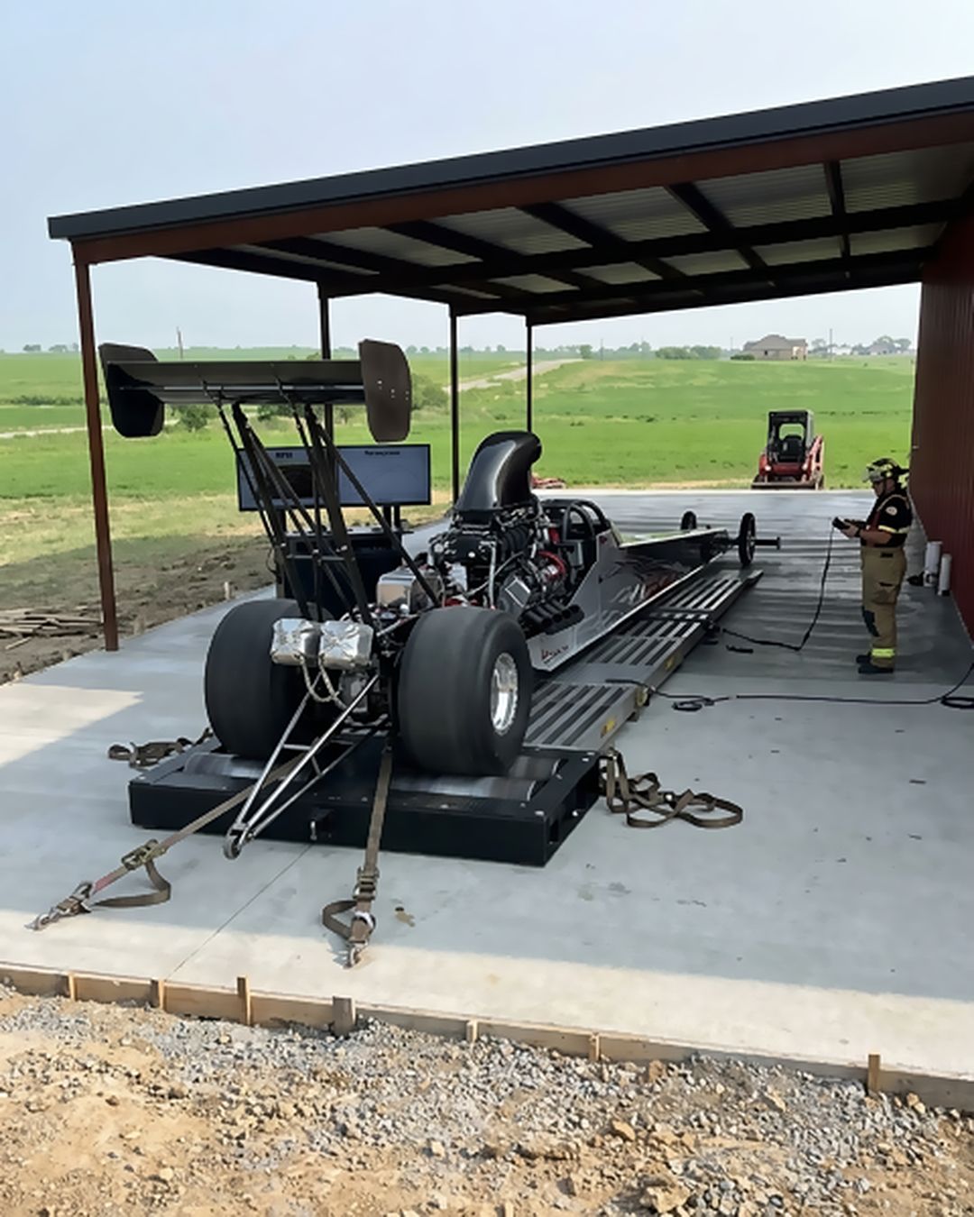 A front-engine dragster strapped down on the dyno pad at Torque Theory